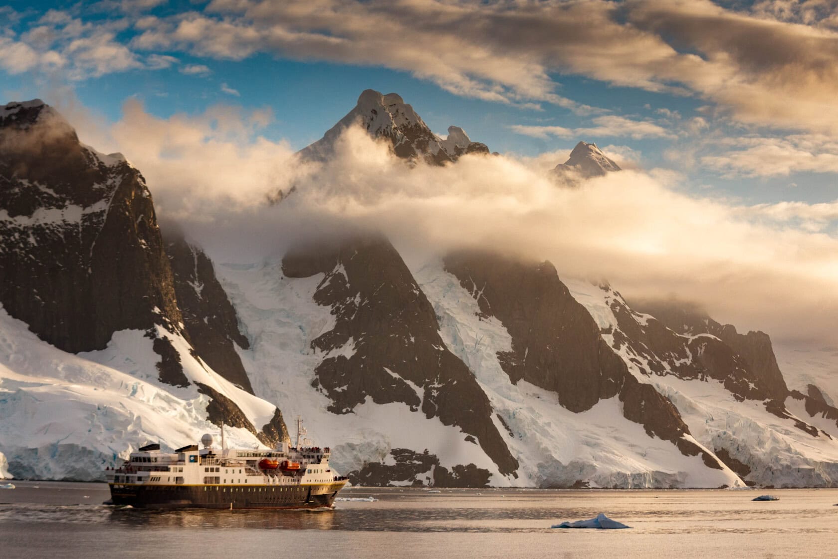 An expedition ship cruises along the Lemaire Channel, Antarctica.