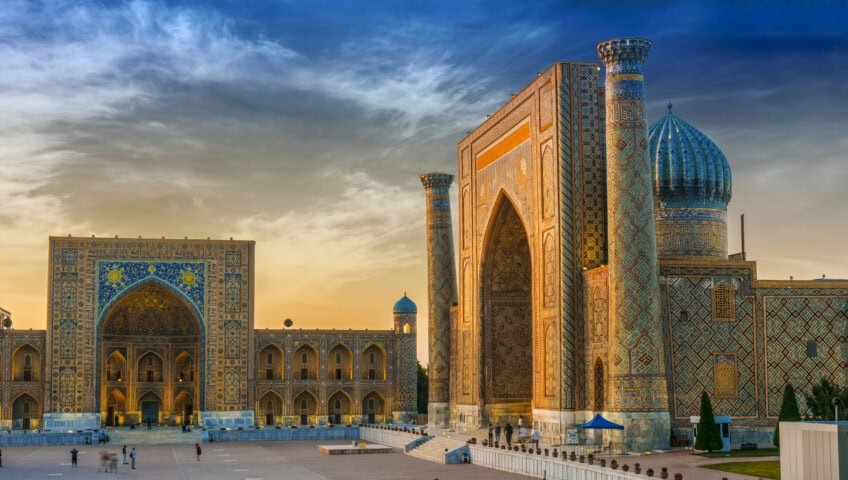 A panoramic view of the Registan, an architectural complex with intricately tiled madrasahs and domes, at sunset in Samarkand, Uzbekistan. This Central Asian gem is a must-see for travel enthusiasts.