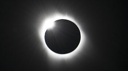 Image of a solar eclipse with the moon almost entirely covering the sun, leaving a ring of light around the darkened moon—a moment reminiscent of Pink Floyd's "Dark Side of the Moon" album.