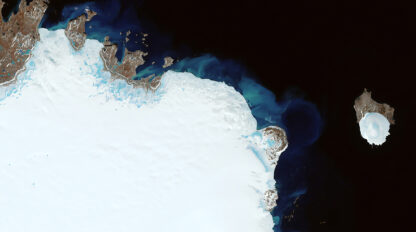 Stunning satellite image showing the northern coast and ice-covered terrain of Greenland with surrounding dark ocean waters and a smaller ice-covered island nearby on Earth.